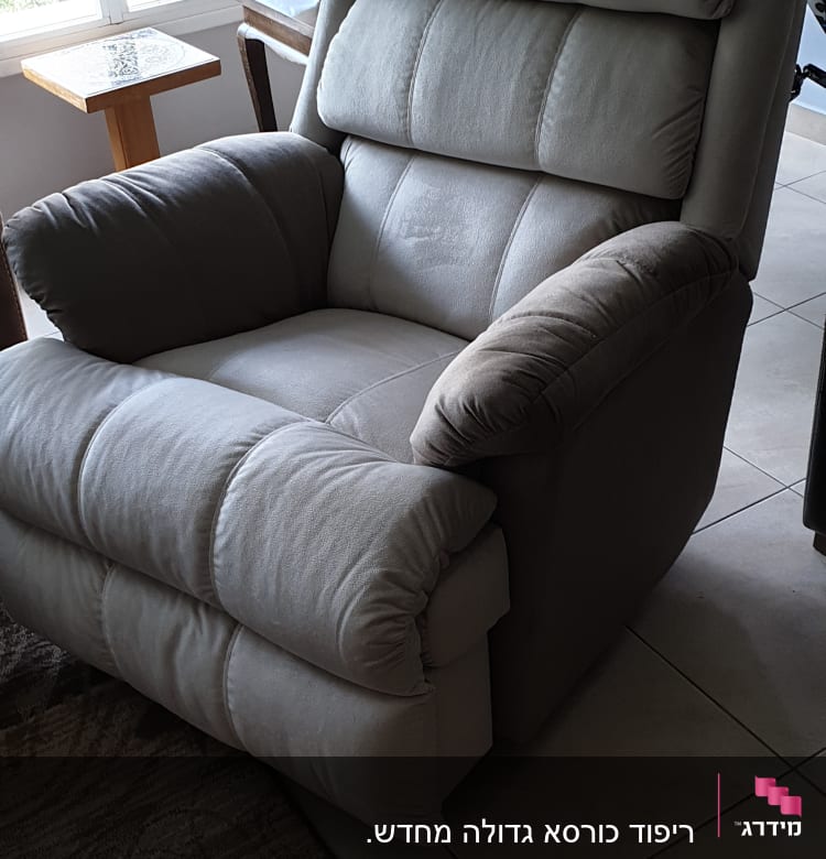 כורסה מרופדת בצבע אפור בהיר עם משענות מרופדות